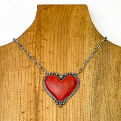 Silver Chain Necklace with Stone Heart Pendant in Red. Pictured on a brown necklace holder on a white background. 