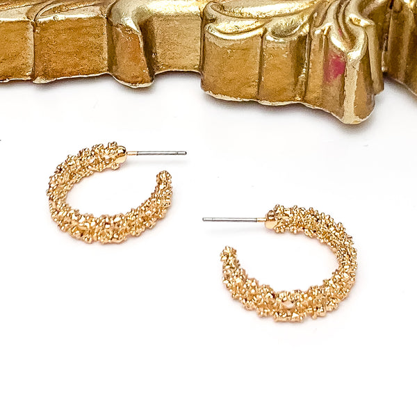 Worry Free Small Silver Tone Textured Hoop Earrings. Pictured on a white background with a gold frame above the earrings.