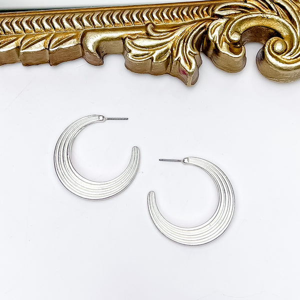 Livin' Life Silver Tone Large Hoop Earrings. Pictured on a white background with a gold frame above the earrings.