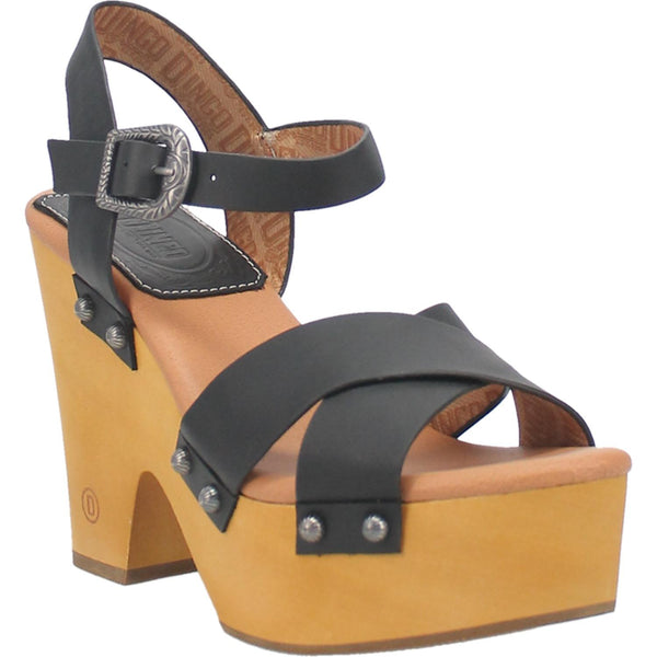 A platform high heeled black sandal with two crossed black straps in the front, black ankle straps with a unique buckle, and circular studs. Item is pictured on a white background.