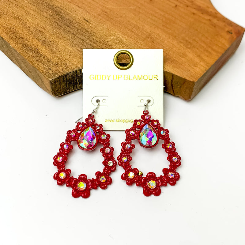 Red open drop earrings with AB crystals and connecting flowers. Pictured on a white background with a wood piece at the top.