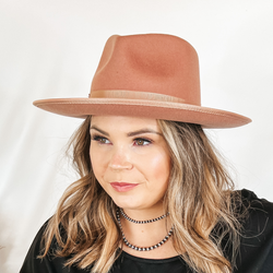 Model is wearing an dusty pink rancher hat with a slightly curved brim.