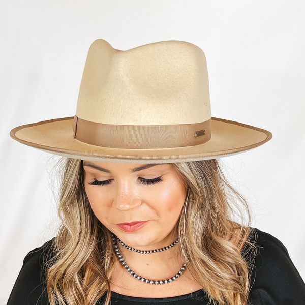 Model is wearing an ivory rancher hat with a curved brim.