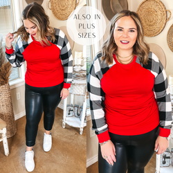 Model is wearing a red top with buffalo plaid long sleeves. Model has it paired with faux leather pants, white sneakers, and gold jewelry.