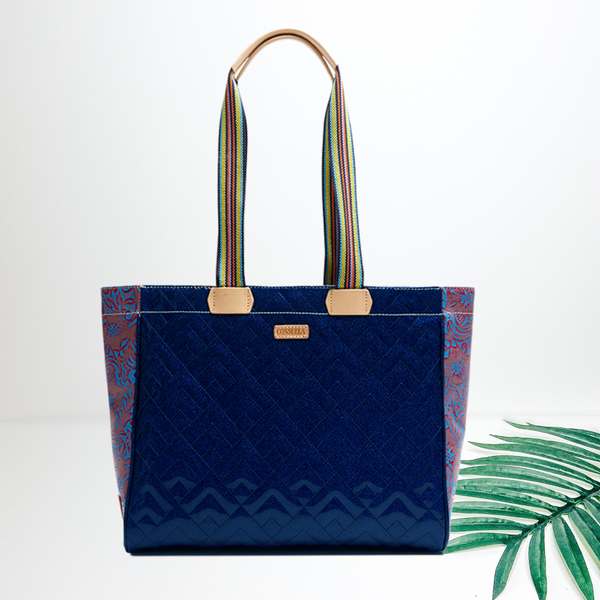 A sparkly blue quilted tote bag pictured on a white background with a palm leaf.