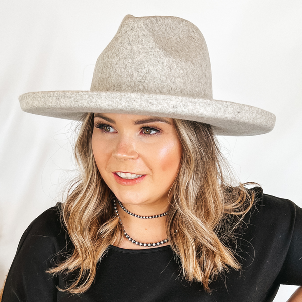 Model is wearing a heather grey wool hat. The hat has a flat brim with a pencil rolled end.