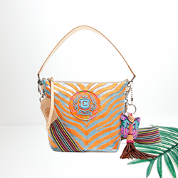 A blue glitter crossbody bag with orange zebra print embroidered on the front. This bag is pictured on a white background with a palm leaf.