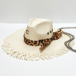 A straw hat with a frayed brim and a leopard print hat band. Pictured on white background with Navajo pearls.