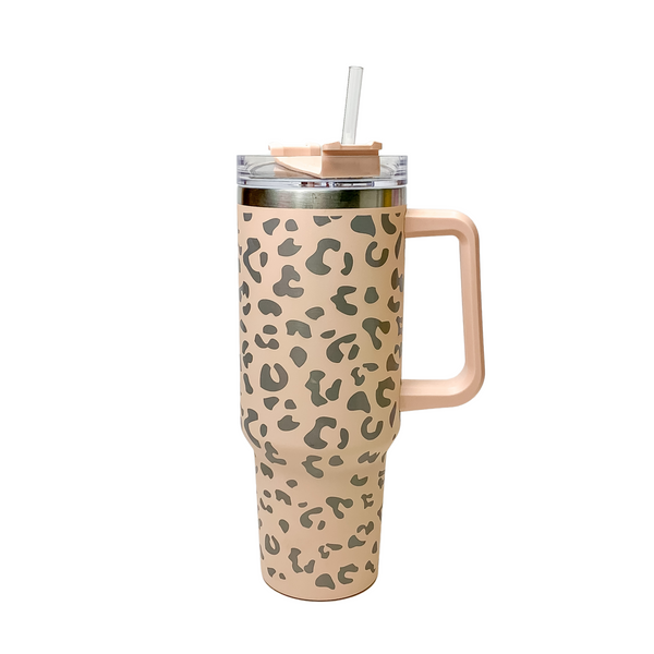 Pictured is a blush nude tumbler with a handle, clear straw, and a leopard print design. This tumbler is pictured on a white background. 