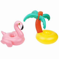 On the left there is an inflatable, pink flamingo drink holder. On the right there is a palm tree on a beach inflatable drink holder. These drink holders are pictured on a white background. 