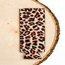 Leopard print slim can koozie pictured laying on a piece of wood on a white background.