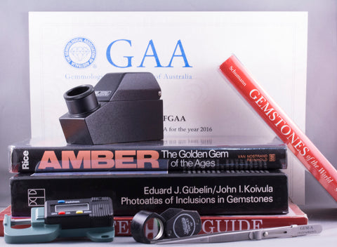 Gemmology certificate and tools with books about amber and gemstones