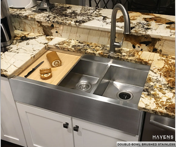 Stainless steel custom farmhouse double bowl sink with a built in ledge and cutting board. Stainless steel kitchen with beautiful granite countertops.