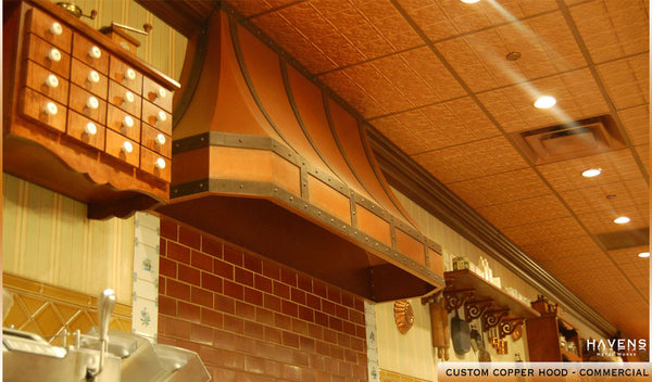 Copper range hood installed in a commercial kitchen with a need for powerful ventilation.