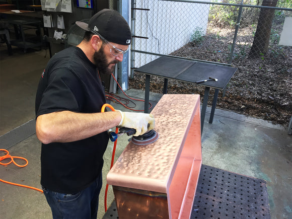 Hand finishing a hammered copper farmhouse kitchen sink