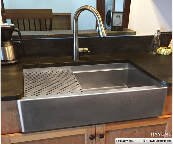 Custom stainless farmhouse sink with a hammered stainless steel finish.