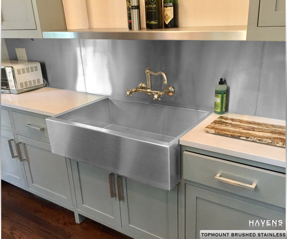 Custom retrofit stainless steel sink with a prominent farmhouse apron front.