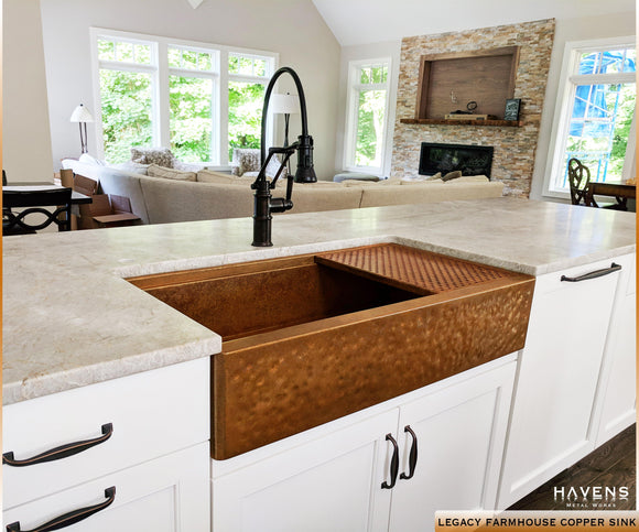 Granite counters and white cabinetry on a custom copper farmhouse sink - rustic style. 