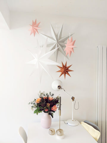 paper star christmas decorations hung over the dining table 