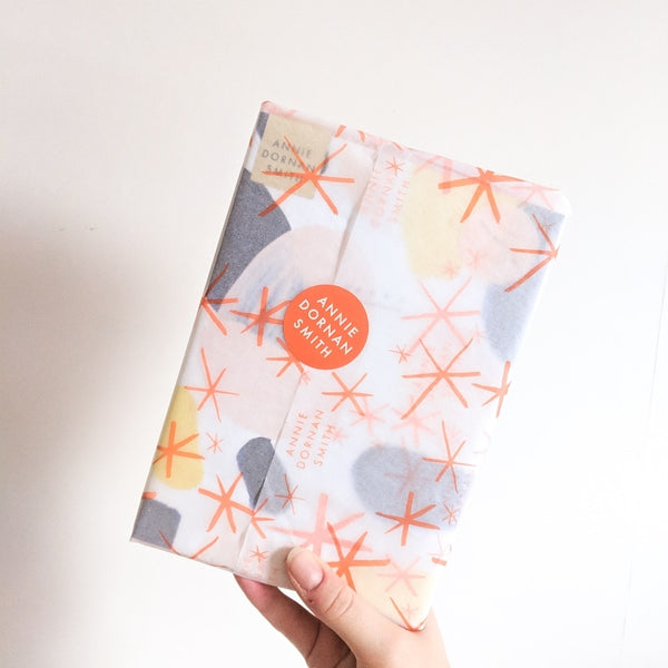 holding the paint swatch notebook, wrapped in pretty tissue paper 