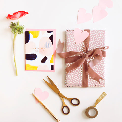 A beautifully wrapped gift, flowers and stationery for valentines day 