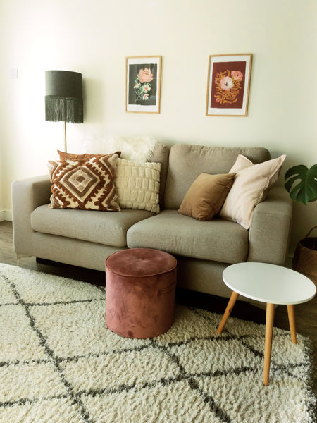 narrow living room style - greige sofa with a mini foot stool, standing lamp and wall art
