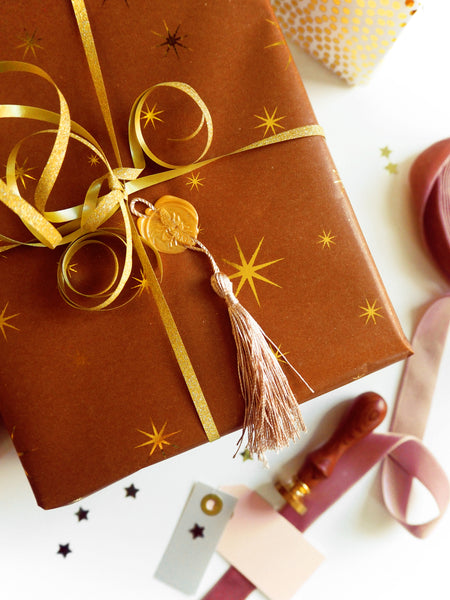 a christmas gift wrapped in gorgeous starry paper and finished with a tasseled, gold wax seal