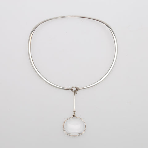 Vivianna Torun Bülow-Hübe Torun necklace with a white Rock Crystal laying on top of a light grey surface