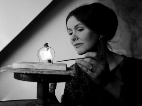 A black and white photo of Vivianna Torun Bülow-Hübe working at her jewelers bench with a blowtorch