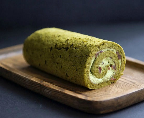 Thin matcha cake sheet spread with matcha red bean cream filling is rolled into classic delicious matcha green tea swiss roll cake