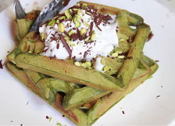 Lovely luscious Matcha Waffle topped with vegan coconut whipped cream, shredded chocolates, and chopped pistachios 