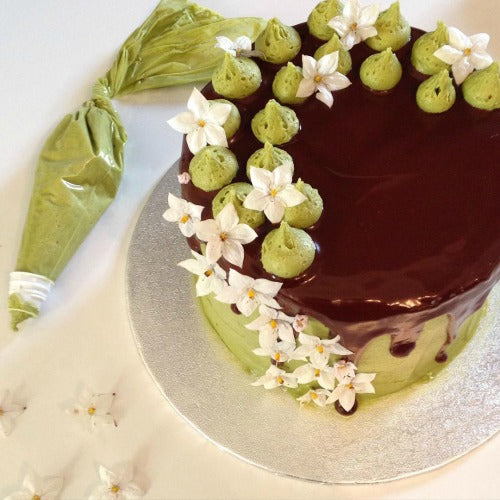 Matcha Chocolate Cake layered with jam and with a hint of coffee is coated with matcha buttercream and chocolate glaze