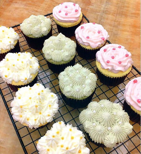 Freshly baked batch of matcha green tea cupcakes topped with matcha buttercream frosting.