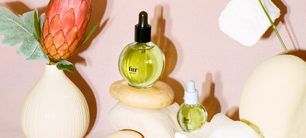 Fur Oil and Ingrown Concentrate alongside plants and painted rocks. 