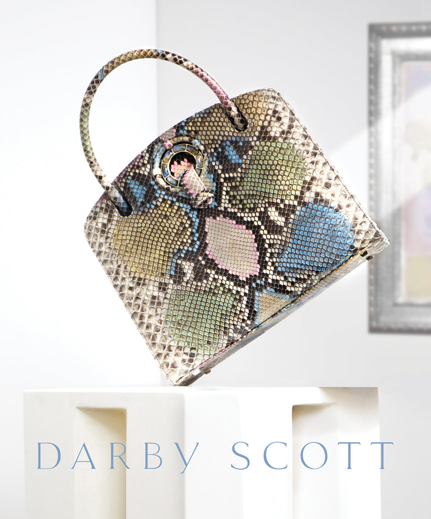 Pastel colored python Annette top handle bag on an ivory pedestal and Darby Scott Logo