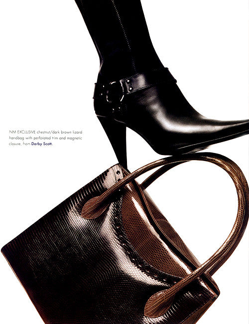 picture of black heeled boot atop a Darby Scott  two tone lizard Thompson tote in chocolate brown with tan accent