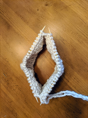 Photo of the beginning of a hat knitted on two Addi FlexiFlip double pointed needles with a white bulky yarn.