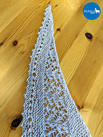 Close-up photo of the knit lace shawl to show the finishing picot bind-off and eyelet row.
