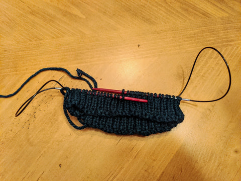 Photo of the beginning of a knit hat on a large circular knitting needle using the magic loop method. 