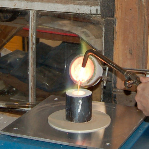 pouring molten metal in to a flask on the casting vacuum table for lost wax casting