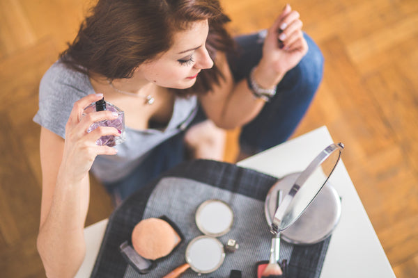 Best Mineral Makeup: Woman sitting down spraying perfume