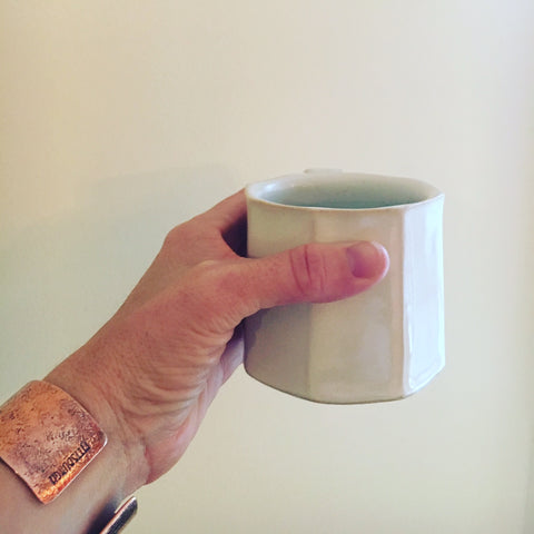 white coffee cup with hand