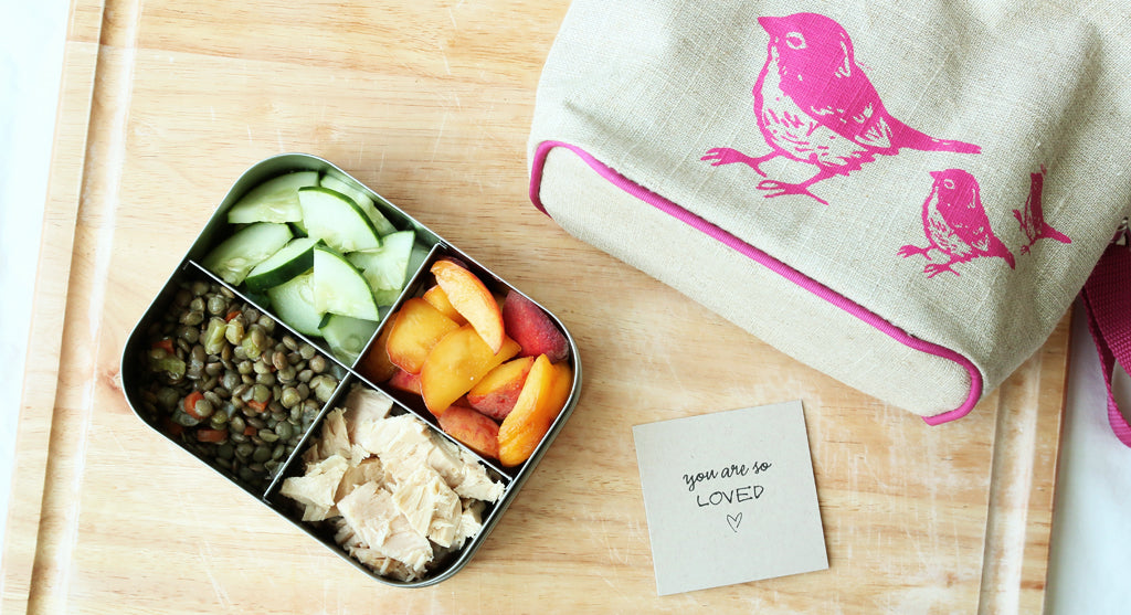 kids lunchbox with healthy food and pink bird lunchbag