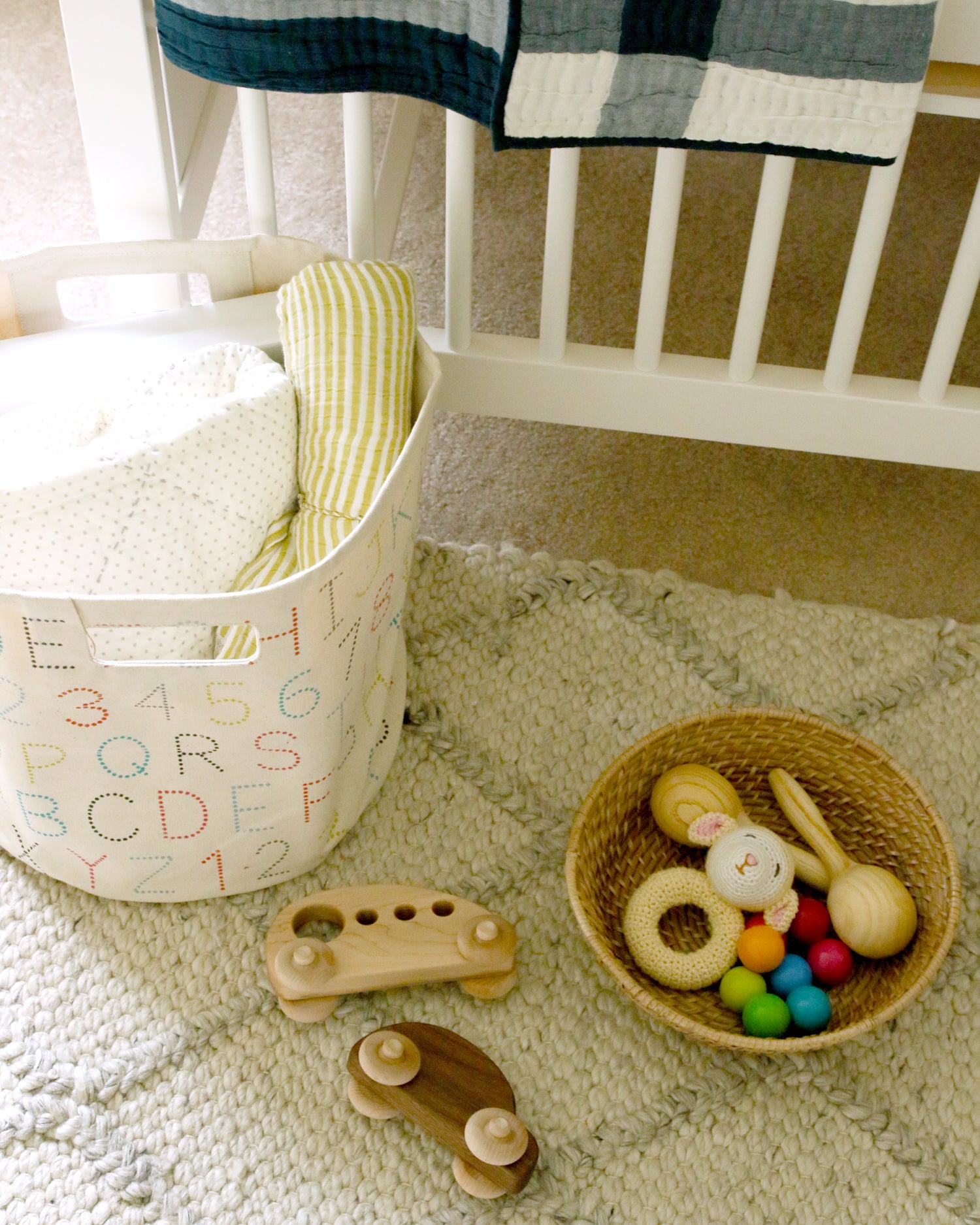 wood car and rattles in baby boy nursery