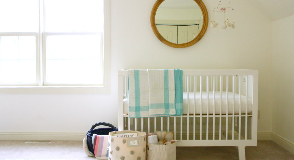 bright girl's nursery with crib and colorful quilt