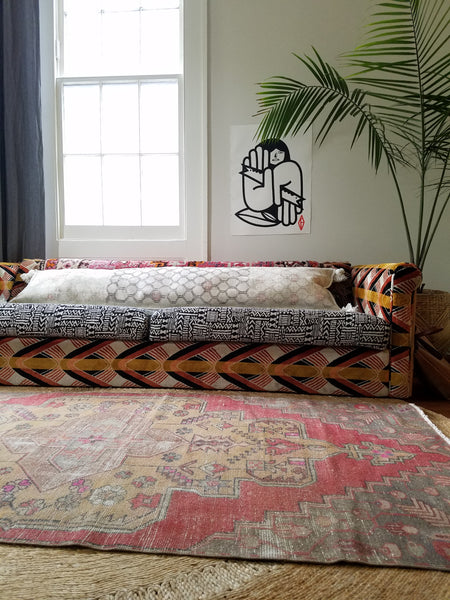 Liz Kamarul living room scene showing turkish rug layered over jute rug with vintage turkish rug turned into a pillow