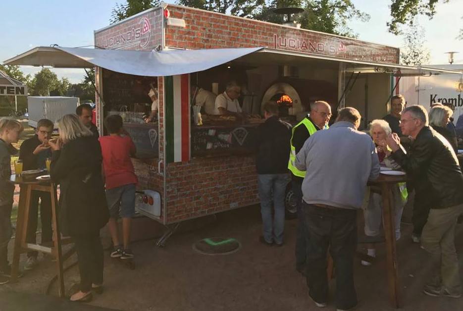 People ordering from a Pizza oven trailer at a food festival