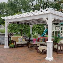 White Vinyl pergola built in garden area with patio furniture