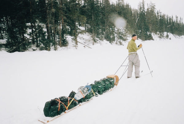 cross country skier, towing a fully loaded hand toboggan
