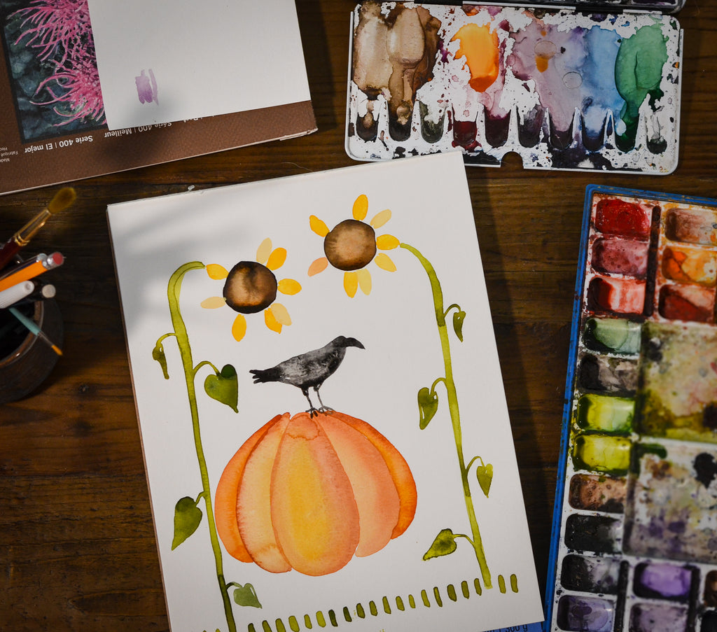 Little Truths Studio arial view of desk paining og pumpkin, sunflowers, crow